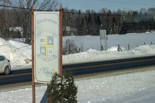Canada, Montreal, 26 December 2025 : Winter Welcome Sign, Snowy Landscape, Rural Road, Clear Sky