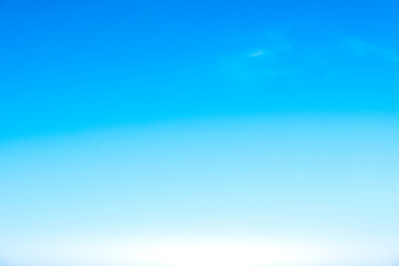 Obraz premium A bright, clear blue sky meets a glowing white horizon, suggesting a serene, open, and with sunlight of beautiful cloudy sky. landscape or abstract background 