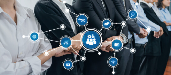 This image depicts a group of diverse professionals holding hands, symbolizing collaboration and networking, surrounded by icons representing modern communication and media. Amity © InfiniteFlow