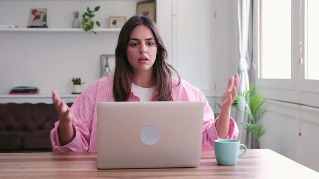 A young woman encounters technical difficulties and expresses visible frustration while working remotely on her laptop. Her exasperation with technology is evident as she struggles to resolve the is