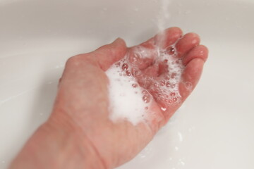 Fototapeta premium Woman washing hands with soap and in bathroom. Hygiene and virus and disinfection. Cleaning hand with soap and water.