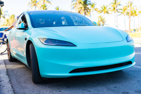 Miami, Florida, USA - July 27, 2025: Tesla Model 3 electric sedan SUV 2023. Electric sedan car car Tesla Model 3. Car Tesla Model 3 parked outdoor. Blue electric sedan car, front view