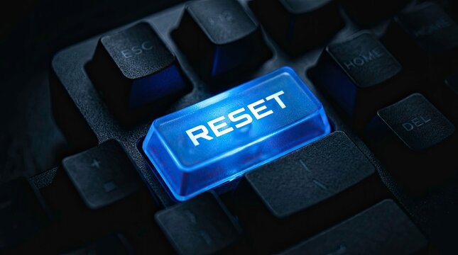 Close-up of keyboard with illuminated reset button, ready to restart computer.