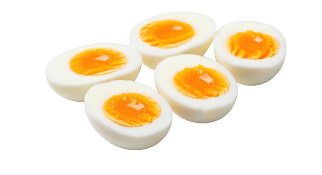 Halved boiled eggs with runny yolks on white