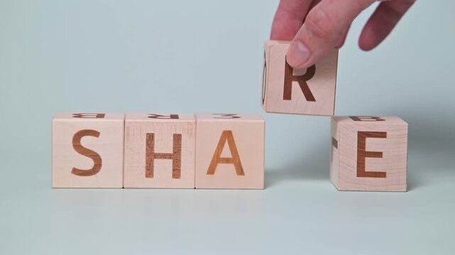 Wooden blocks are arranged to show the words shame and share. A hand interacts with the blocks, changing the letters to emphasize the transformation of meaning