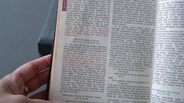 Holy Bible open up to the book of Acts of the new testament, zooming into Chapter 1 verse 8 on receiving power and being witnesses. New Revised Standard Versi