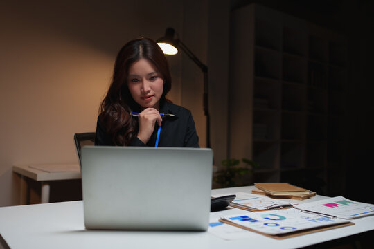 Woman working on laptop late night overtime