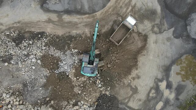 Aerial View of Mining Work in Rock and Ore Quarry, Open Pit Industrial Extraction Site view from above, representing large-scale energy and infrastructure development