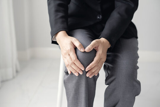 A woman supporting herself from numbness, muscle weakness, pain, and tingling in the knee nerve endings