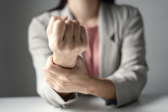 Woman hand with wrist pain numbness and pain in the palm of the hand has pain and tingling in the nerve endings This is a side effect of sitting and working for a long time on a laptop at the office