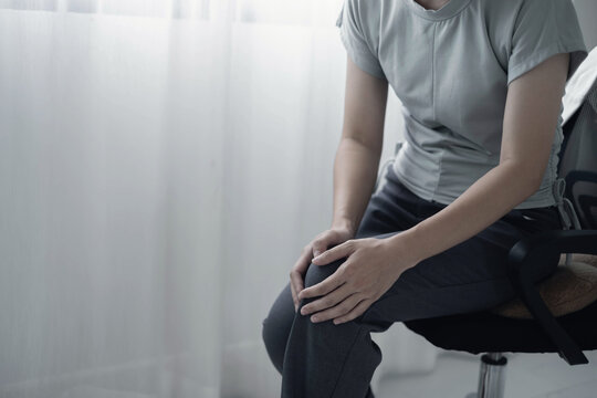 A woman supporting herself from numbness, muscle weakness, pain, and tingling in the knee nerve endings