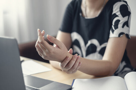 Woman hand with wrist pain numbness and pain in the palm of the hand has pain and tingling in the nerve endings This is a side effect of sitting and working for a long time on a laptop at the office