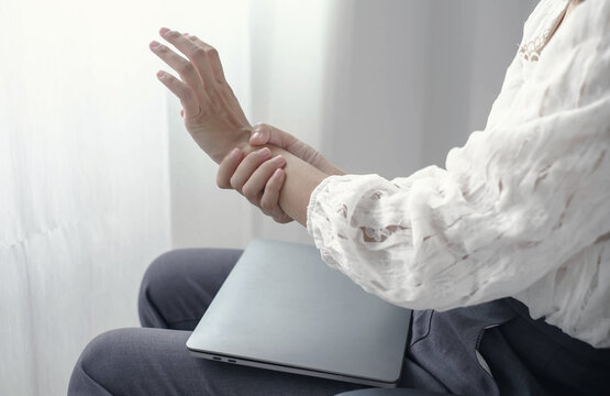 Woman hand with wrist pain numbness and pain in the palm of the hand has pain and tingling in the nerve endings This is a side effect of sitting and working for a long time on a laptop at the office