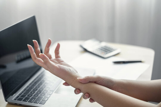 Woman hand with wrist pain numbness and pain in the palm of the hand has pain and tingling in the nerve endings This is a side effect of sitting and working for a long time on a laptop at the office
