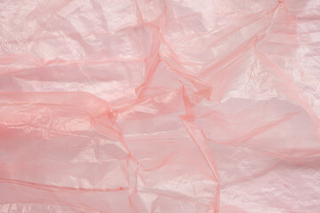 Fototapeta premium Crumpled red plastic texture, wrinkled polyethylene bag surface background
