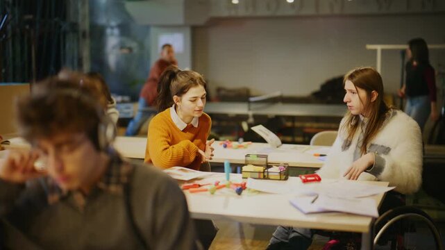Young students engage in collaborative learning, with one student in a wheelchair actively participating. This inclusive classroom setting fosters discussion and support among diverse learners.
