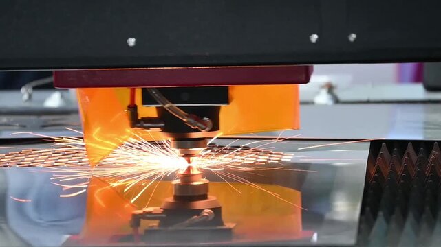 Slow motion video of a fiber laser cutting machine slicing through a metal plate with intense sparks.