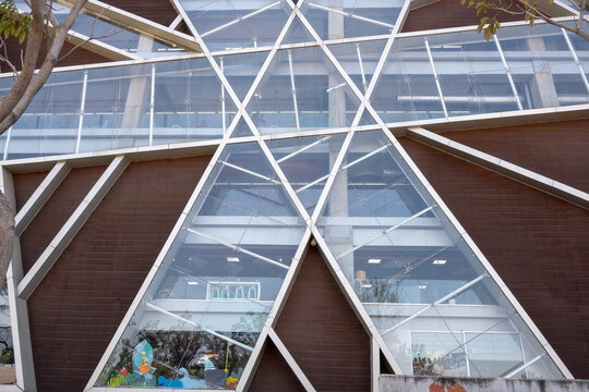 Zapopan, Mexico - February 28 2026: Exterior view of the Jalisco State Public Library Juan Jose Arreola, showcasing its modern geometric glass and brown paneling design under natural light.