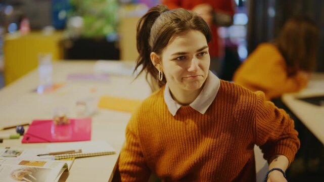 Young students engage in a discussion at a classroom desk. Their positive interaction highlights an inclusive education environment.