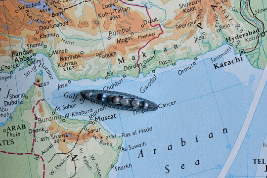Vintage map of the Arabian Sea and Gulf of Oman featuring a toy battleship near the coast of Muscat and Karachi, symbolizing naval strategy, maritime security, and regional geopolitics.