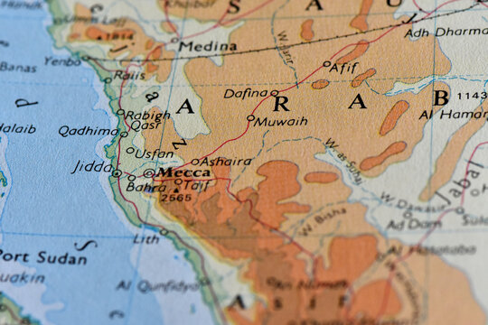 Macro photograph of a vintage political and physical map focusing on Saudi Arabia, highlighting the cities of Mecca and Medina alongside the Red Sea coast.