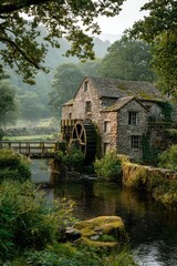 Obraz premium Old stone mill by a quiet stream, lush greenery and soft morning light
