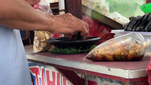 Indonesian Street Food Vendor Grinding Peanut Sauce in Mortar
