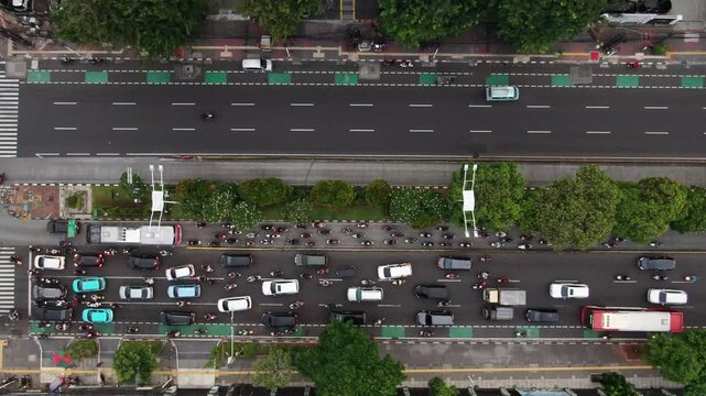 Aerial Top View of Extreme Traffic Contrast on City Main Road. One Side Densely Packed with Cars and Motorcycles causing Congestion while the Opposite Lane remains Empty. Urban Mobility and Commuting