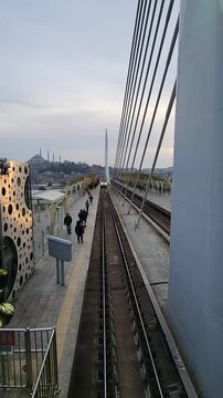 Beautiful aerial footage of the Halic tram passing through Istanbul with iconic mosque architecture in the background. Urban travel scenery with cultural city atmosphere.