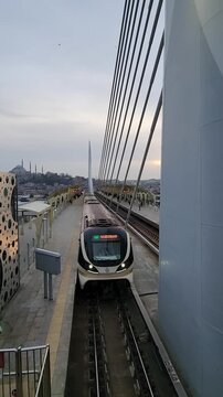 Beautiful aerial footage of the Halic tram passing through Istanbul with iconic mosque architecture in the background. Urban travel scenery with cultural city atmosphere.