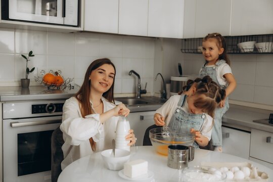 Mother and daughters baking in modern kitchen
