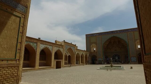  Open courtyard scene of a historic mosque with surrounding arcades and a central open space, representing traditional Islamic architecture and communal religious life. 