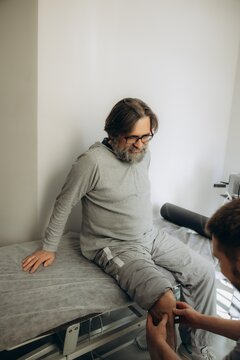 Male patient receiving physical therapy for leg injury