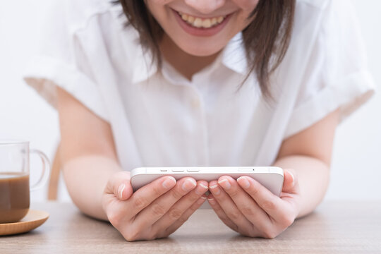 スマホを横持ちし楽しむ女性