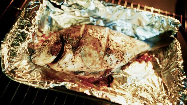 Roasted Dorado Fish Baked in Aluminum Foil. Seafood Cooking Process