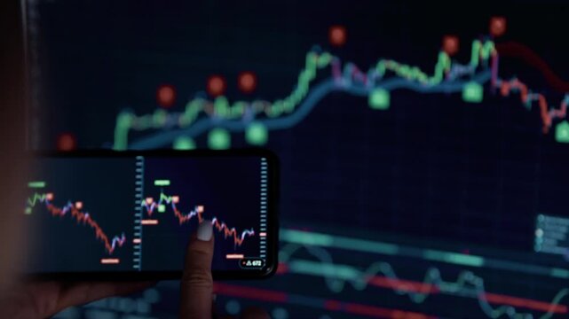 Trader Analyzing Stock Market Charts On Smartphone And Computer Screen. Finance Analytics and Statistics Management
