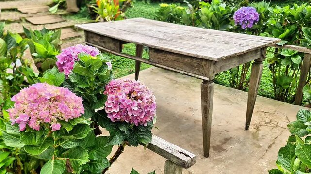 Rustic Wooden Table in Beautiful Flower Garden with Traditional Javanese House Background