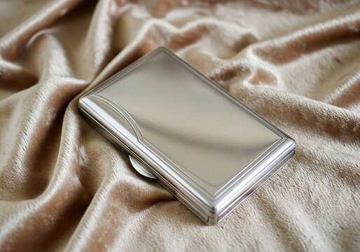 Elegant silver cigarette case resting on soft, luxurious satin fabric