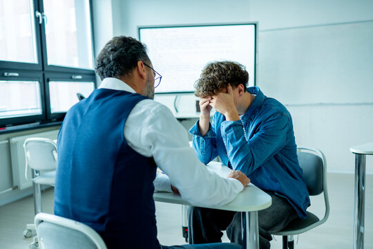 Teacher supporting struggling student. Boy confiding in a teacher.
