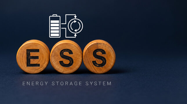 Three warm wood discs spelling ESS with a battery-stack and flow-charge icon above on a deep midnight-navy background for energy storage systems.