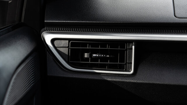 interior car air conditioning grill and dashboard detail with sleek silver border.