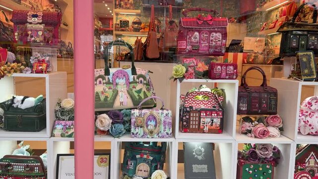 A vibrant storefront window of a Vendula London boutique showcases a collection of uniquely designed novelty handbags and accessories