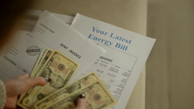 Counting Cash Dollars To Pay Energy Bill And Rent Invoice. Monthly Expenses and Household Budget