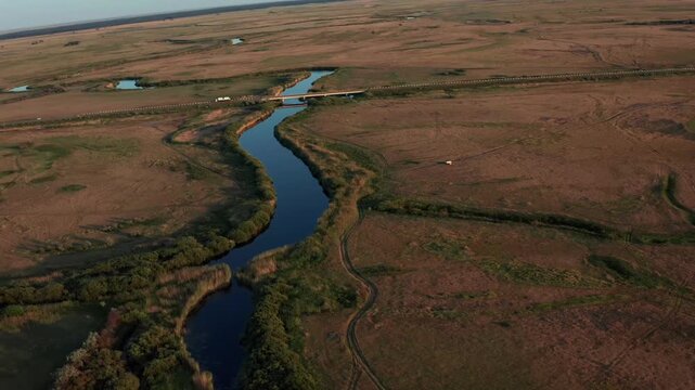 Drone aerial panorama of Ubagan river flowing across wide steppe plains in Kostanay region Kazakhstan, natural landscape with winding water channel, dry grasslands and vast open horizon