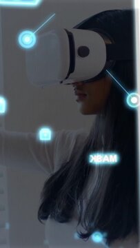 Vertical video: Woman with VR headset raising hand tapping floating UI nodes for tech demo