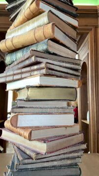 Stacked antique books with warm light under colorful ceiling