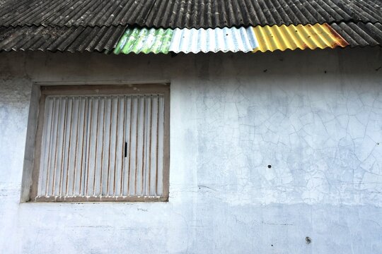 The zinc roof on an old house painted in various colors among the moldy asbestos roof