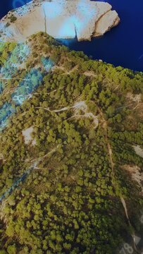 Vertical video: Drone sweeping cape on cue tilting showing cliff as flare and ticker rising mapping