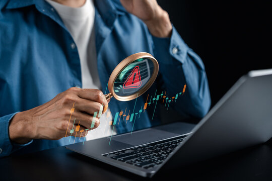 Investment risk analysis concept. Person holding magnifying glass with warning sign and candlestick chart graphic.