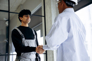 Obraz premium Construction worker and engineer shaking hands, finalizing a business deal on a building site. Teamwork, agreement and collaboration